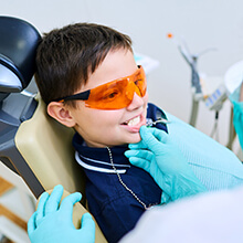 Young boy in safety glasses receives dental sealants