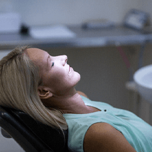 Woman relaxing in a dental chair with eyes closed