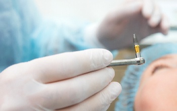 Dentist placing dental implant after examining CBCT scan