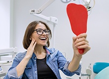 Young woman admiring her new dental implants in Westfield