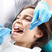 Young girl examined following dental sealant placement