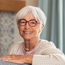 Senior woman sitting on her couch and smiling