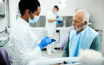 mature man talking to dentist about dentures in Westfield