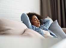 Woman in denim jacket relaxing on couch
