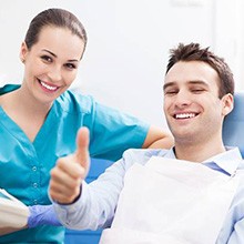 Man in dental chair giving thumbs up