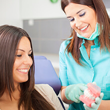 Woman and dentist examine smile model