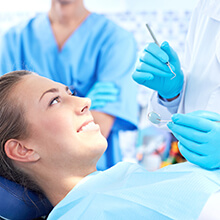 Woman in dental chair talking to dentist