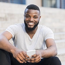 Young man sitting on stairs after wisdom tooth extraction in Westfield, NJ