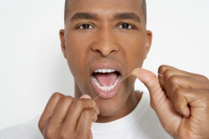 Man flossing teeth, portrait