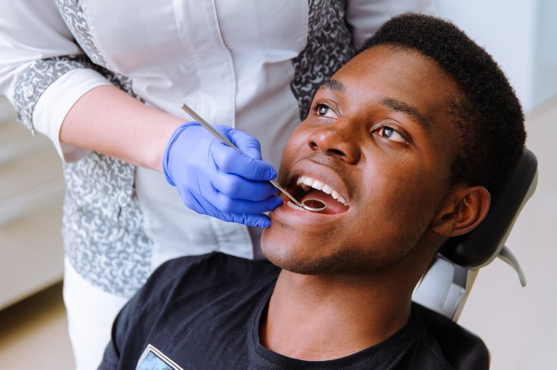 a young man having his teeth checked at the dentist’s office