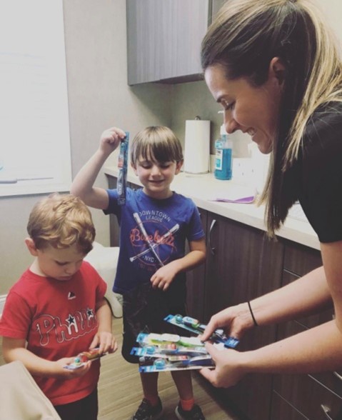 Dental hygienist helping kids pick out toothbrush