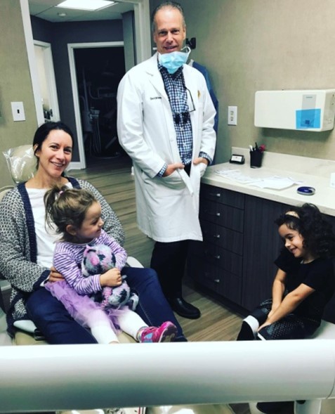 Dr. Weinman smiling with family at dental checkup
