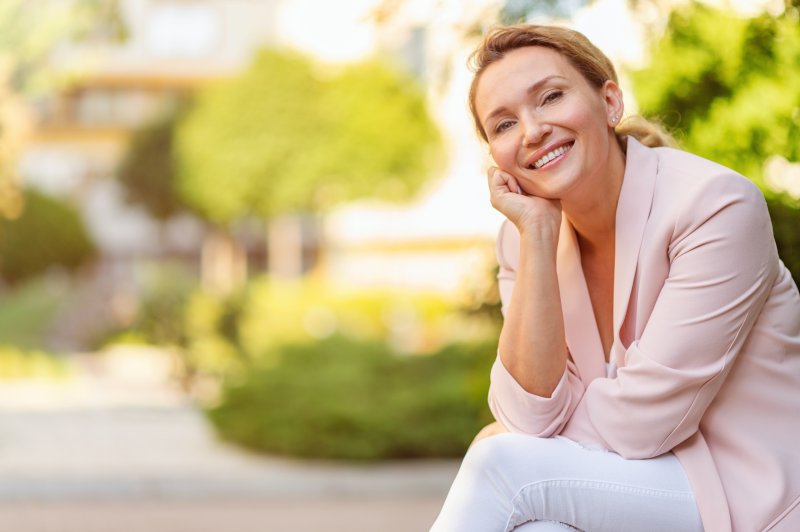 Woman in the middle of a park smiling