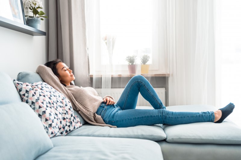 Woman sitting on her couch after tooth extraction