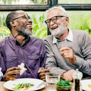 older man laughing with friend 