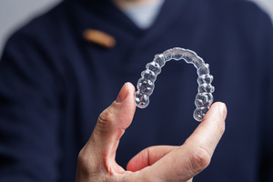 Close-up of man holding a Spark clear aligner